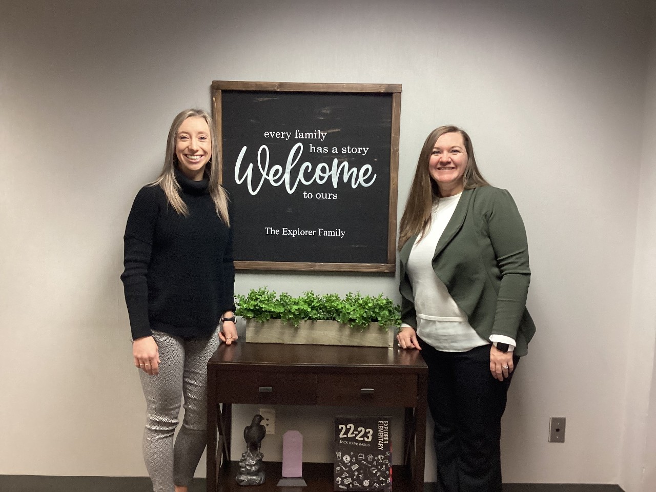 Principal Kristin Driver and Assistant Principal Nicole Novato stand in front of a welcome sign at Explorer Elementary School.